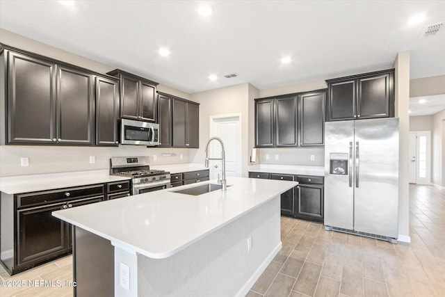 kitchen with visible vents, stainless steel appliances, wood tiled floor, and a sink