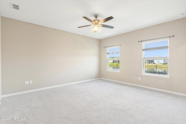 spare room featuring visible vents, ceiling fan, baseboards, and carpet floors