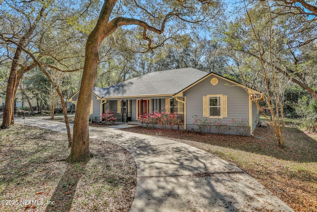 ranch-style home featuring a porch, concrete driveway, and a shingled roof