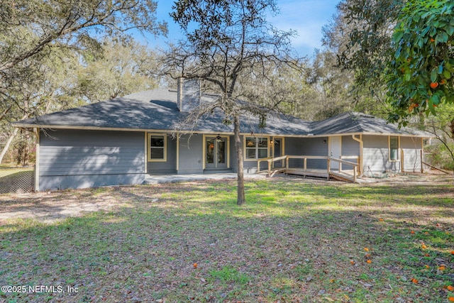 rear view of house with a patio, a lawn, and french doors