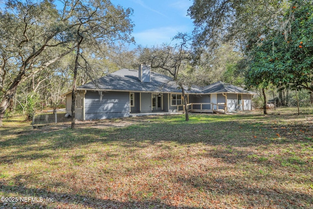 back of property with a yard and a chimney