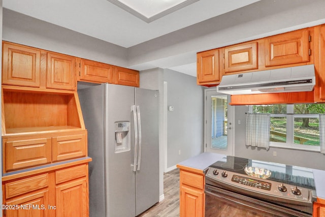 kitchen with baseboards, stainless steel appliances, light countertops, exhaust hood, and light wood-type flooring