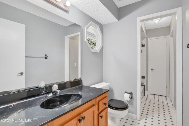 bathroom with tile patterned floors, toilet, a textured ceiling, and vanity