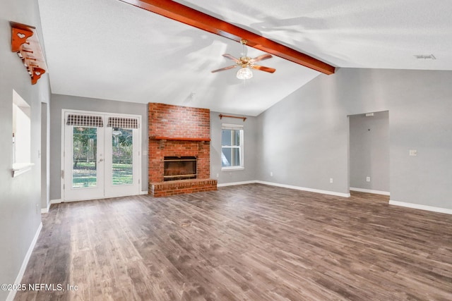 unfurnished living room featuring wood finished floors, vaulted ceiling with beams, a healthy amount of sunlight, and ceiling fan