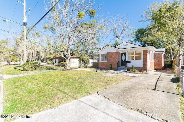 view of front of home featuring brick siding, driveway, a front yard, and fence