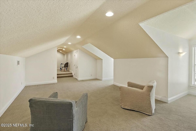 bonus room featuring light carpet, baseboards, and a textured ceiling