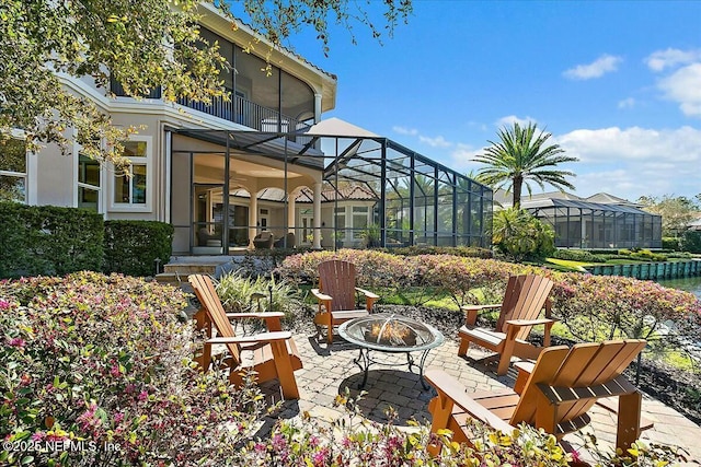 view of patio featuring a lanai and a fire pit