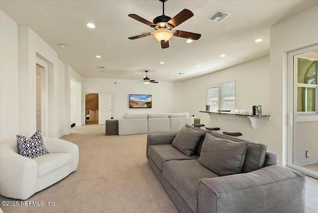 living area with light carpet, recessed lighting, visible vents, and ceiling fan