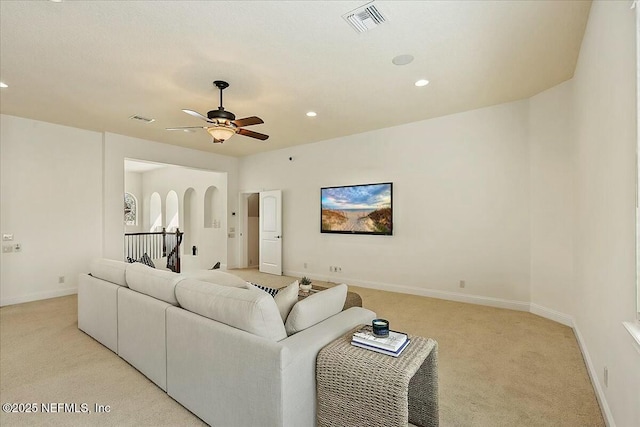 living room with visible vents, baseboards, light carpet, and a ceiling fan