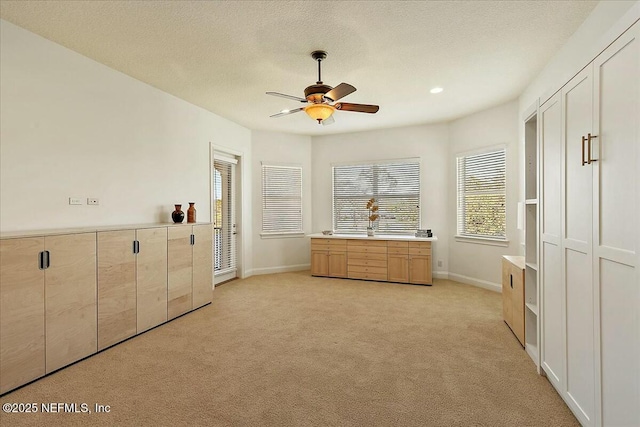 unfurnished bedroom featuring baseboards, ceiling fan, light carpet, recessed lighting, and a textured ceiling