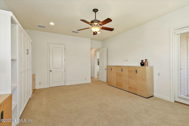 unfurnished bedroom with light carpet, visible vents, and baseboards