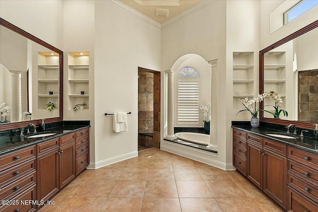 bathroom featuring tile patterned floors, built in features, ornate columns, and a sink