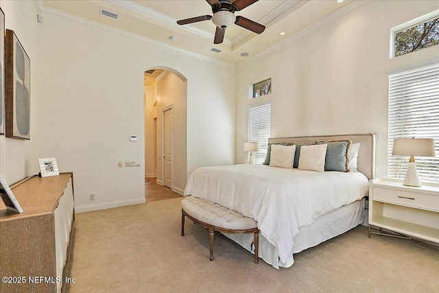 bedroom featuring visible vents, a tray ceiling, arched walkways, light carpet, and crown molding