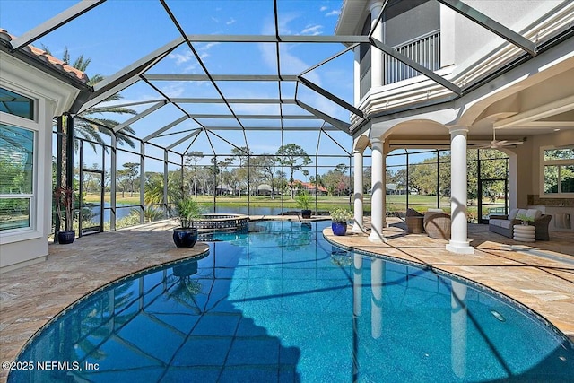 view of pool featuring glass enclosure, an outdoor hangout area, a pool with connected hot tub, and a patio area