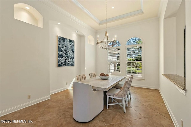 dining room with ornamental molding, a tray ceiling, an inviting chandelier, tile patterned flooring, and baseboards