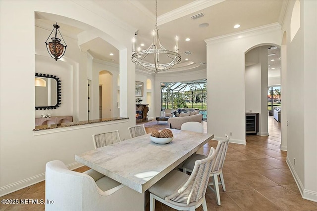 dining space with tile patterned floors, a chandelier, wine cooler, and ornamental molding