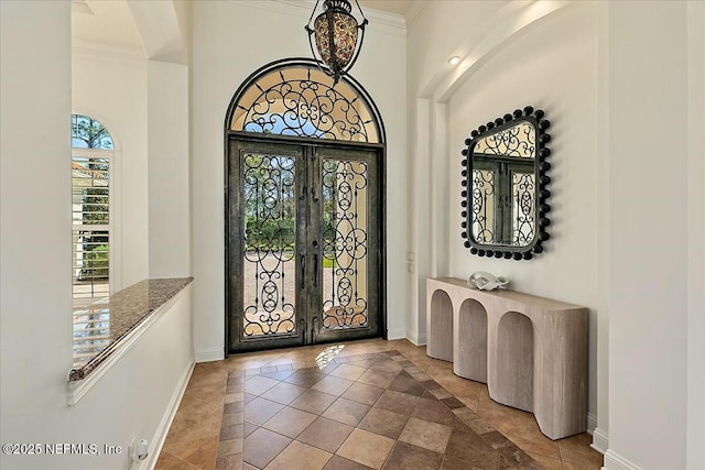 entryway featuring crown molding, french doors, and baseboards