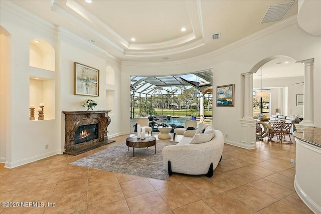 living room with light tile patterned floors, visible vents, ornamental molding, and decorative columns