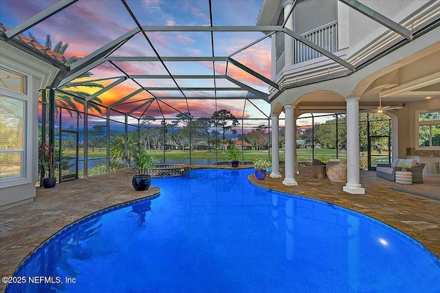 view of swimming pool featuring glass enclosure, a patio area, and a pool with connected hot tub