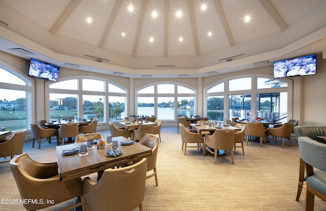 dining room featuring visible vents, beamed ceiling, high vaulted ceiling, and light colored carpet