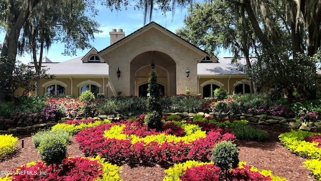 view of front facade featuring stucco siding and a chimney