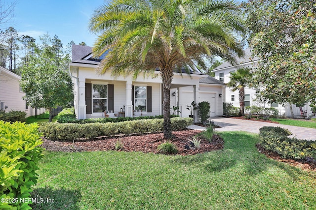 view of front of property featuring driveway, fence, roof with shingles, a front yard, and a garage