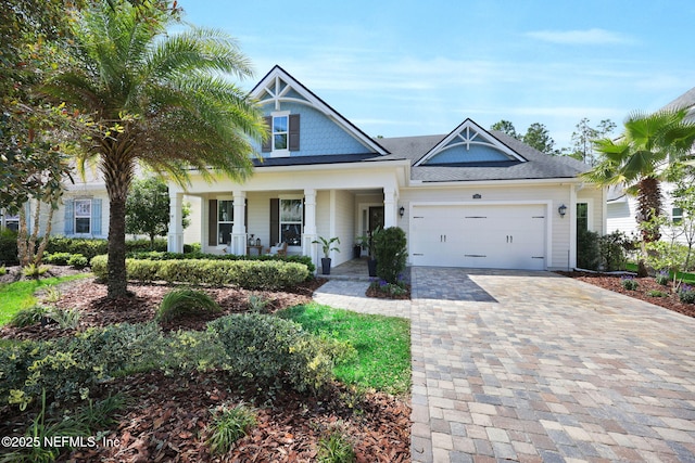 view of front of property featuring covered porch, an attached garage, and decorative driveway