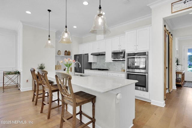 88 Village Grande Dr, Ponte Vedra, FL 32081 - kitchen featuring crown molding, under cabinet range hood, a kitchen bar, decorative backsplash, and stainless steel appliances