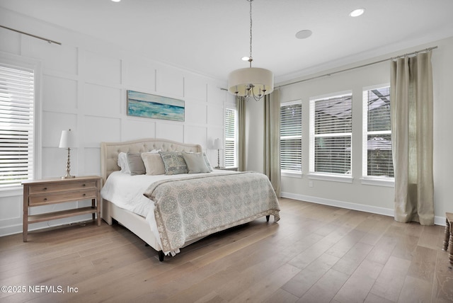 88 Village Grande Dr, Ponte Vedra, FL 32081 - bedroom with multiple windows, light wood-style floors, an inviting chandelier, and a decorative wall