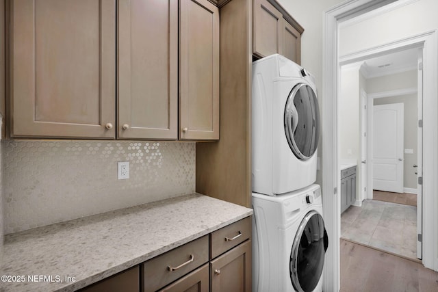 88 Village Grande Dr, Ponte Vedra, FL 32081 - clothes washing area with stacked washer and clothes dryer, light wood-style flooring, ornamental molding, cabinet space, and baseboards