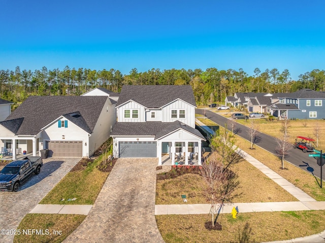traditional home with a residential view, decorative driveway, board and batten siding, and roof with shingles