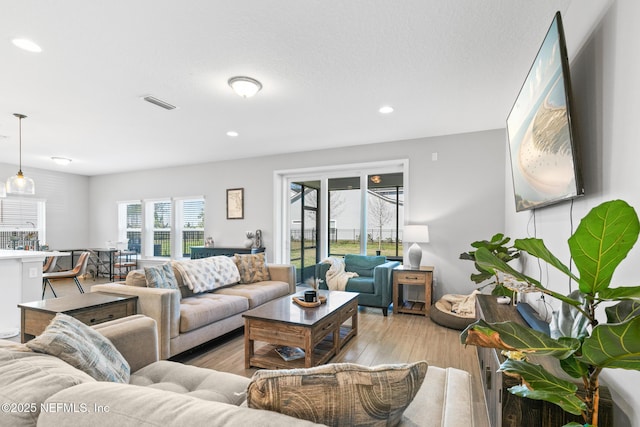 living room with visible vents, recessed lighting, and light wood finished floors