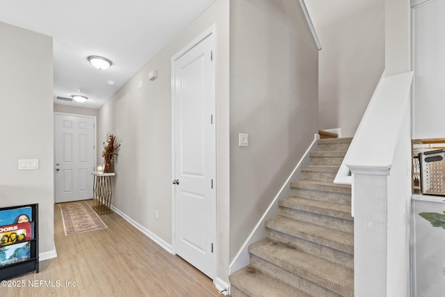 staircase with baseboards and wood finished floors