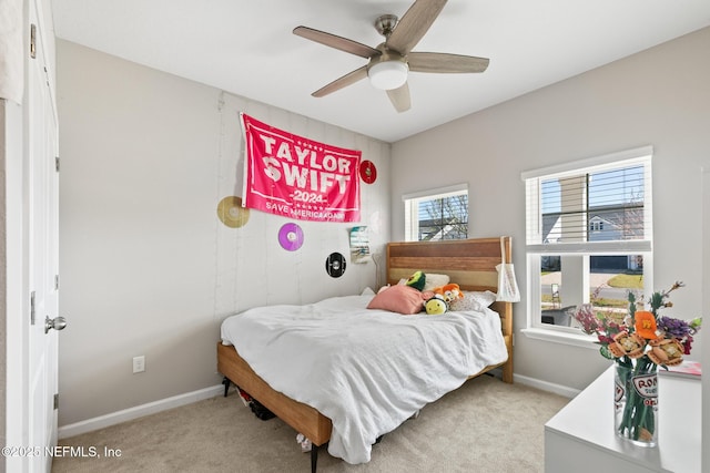 bedroom featuring baseboards, light colored carpet, and ceiling fan