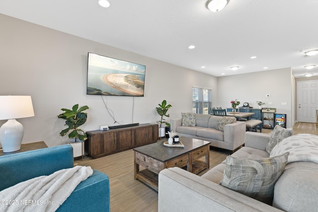 living area with light wood-type flooring and recessed lighting