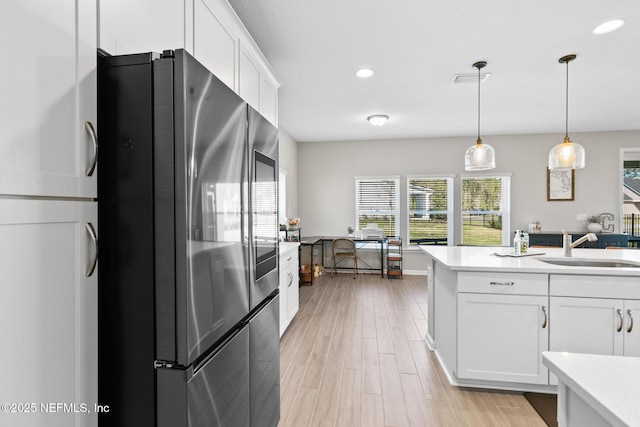 kitchen with light countertops, a sink, white cabinetry, light wood-type flooring, and smart refrigerator