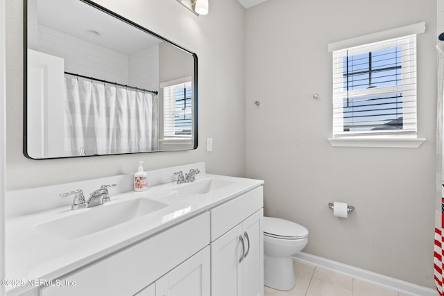 bathroom with toilet, tile patterned floors, a sink, and double vanity