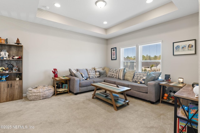 living area with light colored carpet, recessed lighting, and a raised ceiling