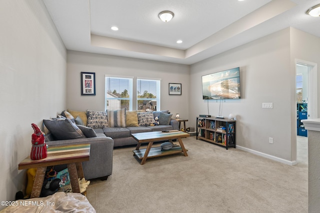 living area with carpet flooring, a tray ceiling, baseboards, and recessed lighting