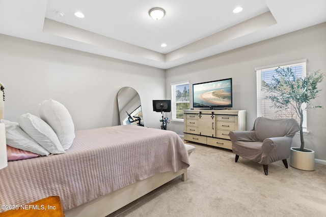 bedroom featuring a raised ceiling, light colored carpet, and recessed lighting