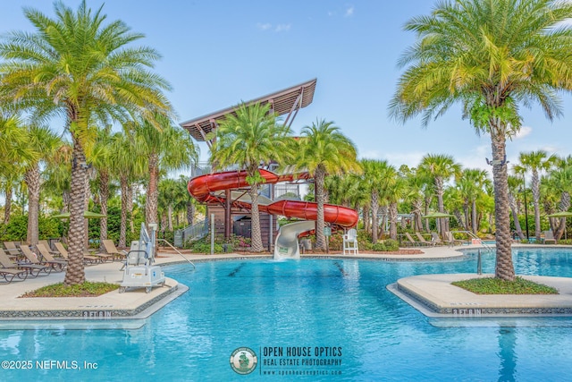 community pool with a water slide and a patio