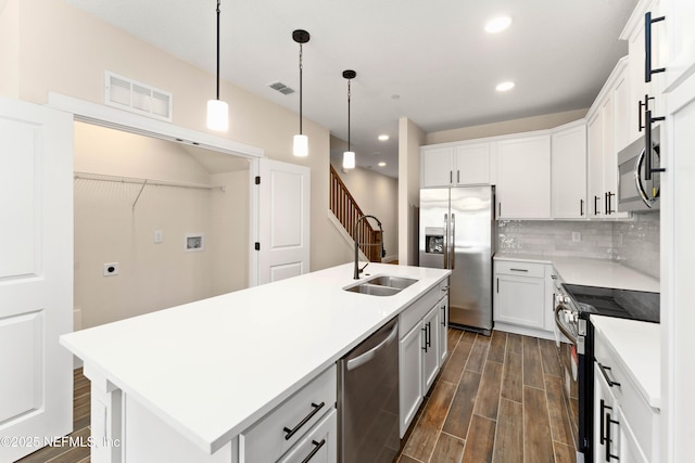 kitchen with visible vents, stainless steel appliances, wood finish floors, and a sink