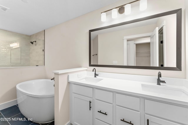 full bathroom with tile patterned floors, visible vents, a tile shower, and a sink