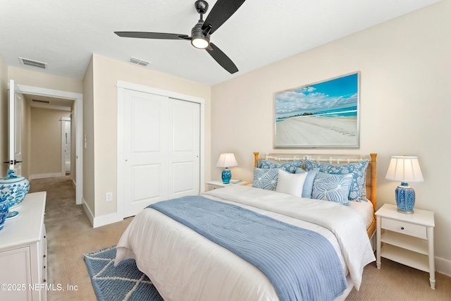 bedroom featuring baseboards, visible vents, a closet, and light carpet