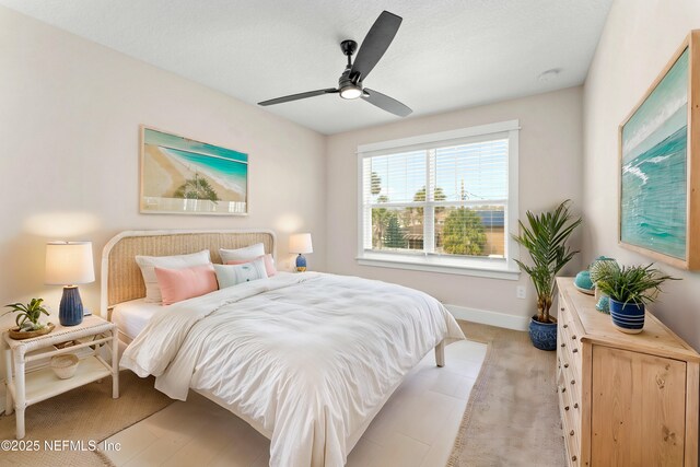 bedroom featuring light carpet, ceiling fan, and baseboards