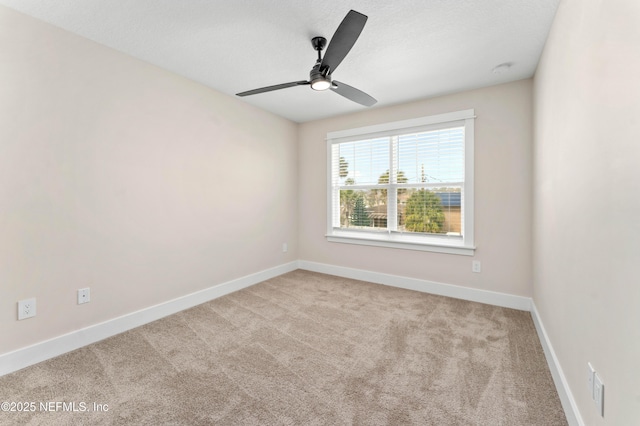 carpeted spare room featuring baseboards, a textured ceiling, and a ceiling fan