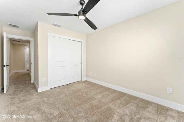 unfurnished bedroom with visible vents, baseboards, and light colored carpet