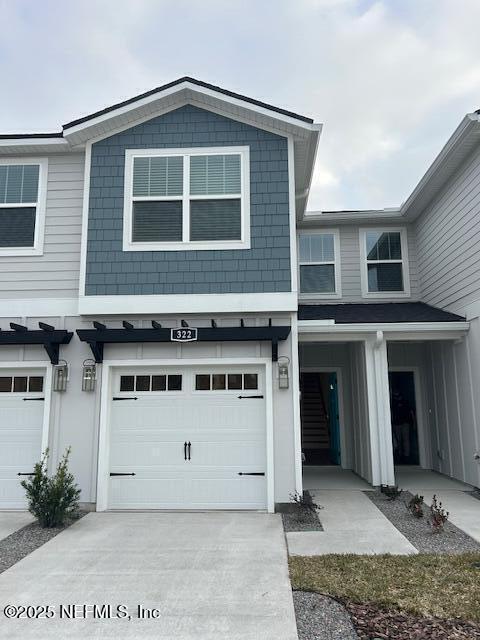 view of property featuring an attached garage and concrete driveway