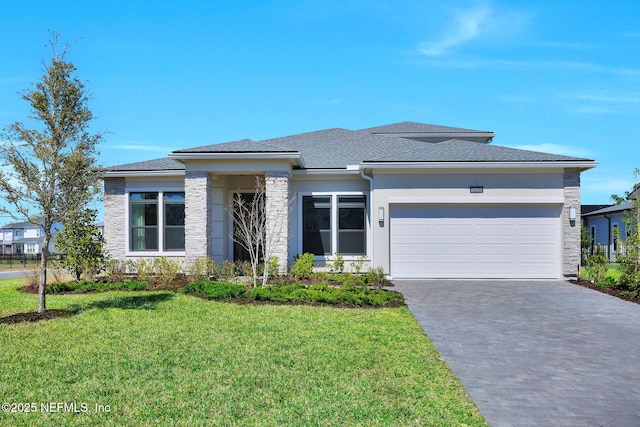 prairie-style home with stucco siding, a front lawn, driveway, stone siding, and a garage