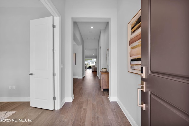 corridor featuring baseboards and wood finished floors